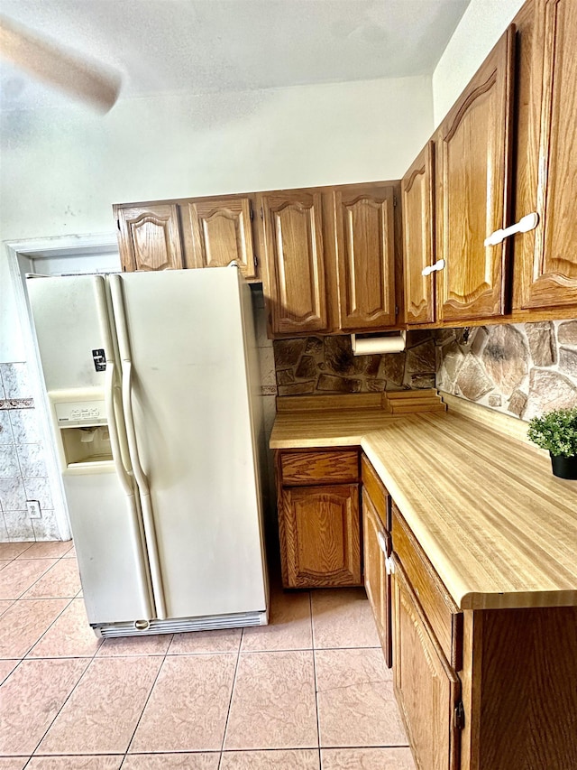 306 Columbia Ave, Jersey City, NJ 07307 - kitchen with white refrigerator with ice dispenser, tasteful backsplash, light countertops, brown cabinetry, and light tile patterned floors