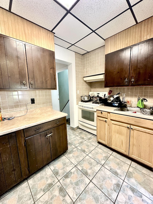 306 Columbia Ave, Jersey City, NJ 07307 - kitchen featuring white range, under cabinet range hood, backsplash, a paneled ceiling, and light countertops