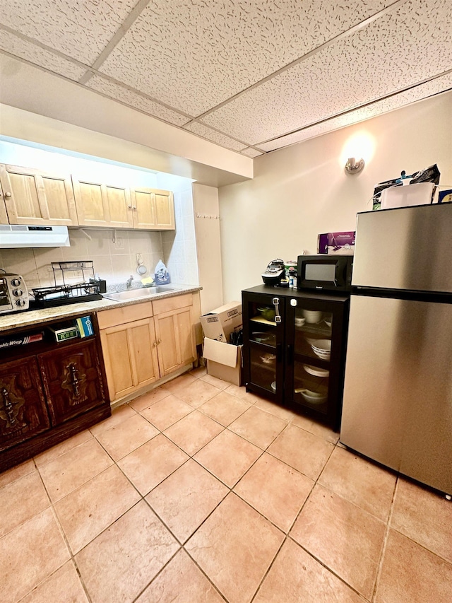 306 Columbia Ave, Jersey City, NJ 07307 - kitchen featuring freestanding refrigerator, a drop ceiling, under cabinet range hood, light brown cabinets, and light countertops