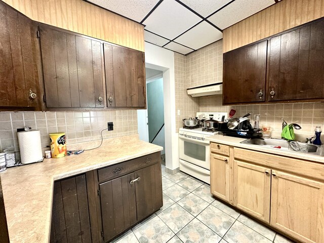 306 Columbia Ave, Jersey City, NJ 07307 - kitchen featuring white gas range, decorative backsplash, light countertops, and a paneled ceiling