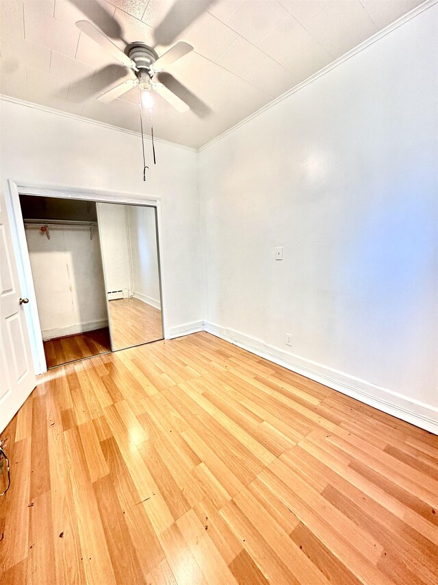 306 Columbia Ave, Jersey City, NJ 07307 - unfurnished bedroom with light wood-type flooring, a closet, ornamental molding, a ceiling fan, and baseboard heating