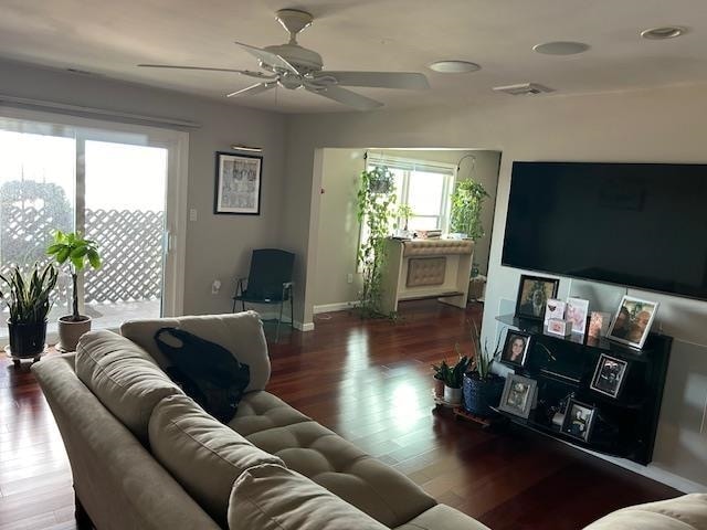 living room with ceiling fan and dark wood-type flooring