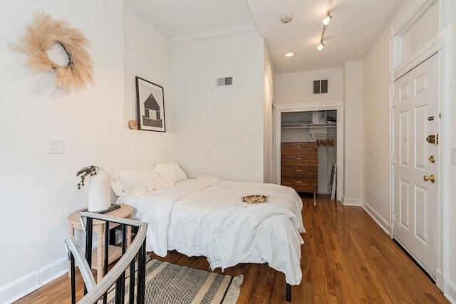 bedroom featuring a closet, wood finished floors, and baseboards