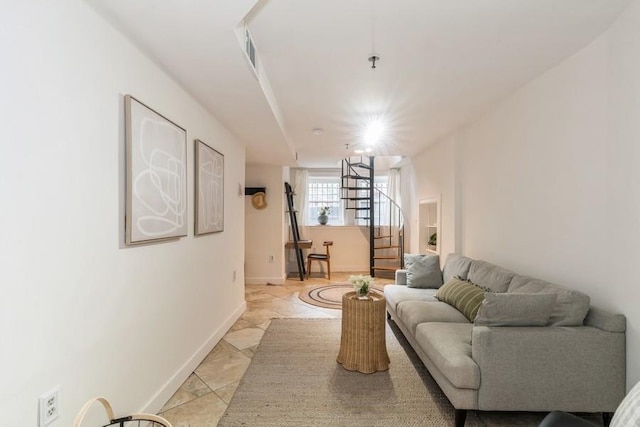 living room featuring stairs and baseboards