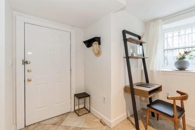 doorway to outside with baseboards and light tile patterned floors