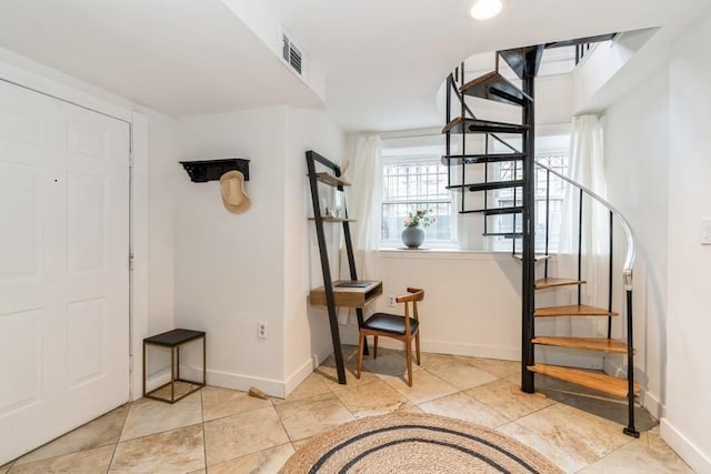 tiled foyer featuring stairs and baseboards