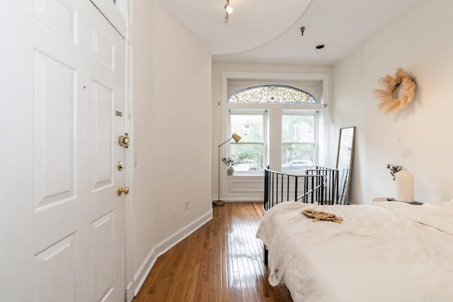 bedroom featuring wood-type flooring and baseboards