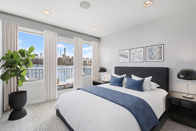 carpeted bedroom featuring a water view, baseboards, recessed lighting, and access to exterior