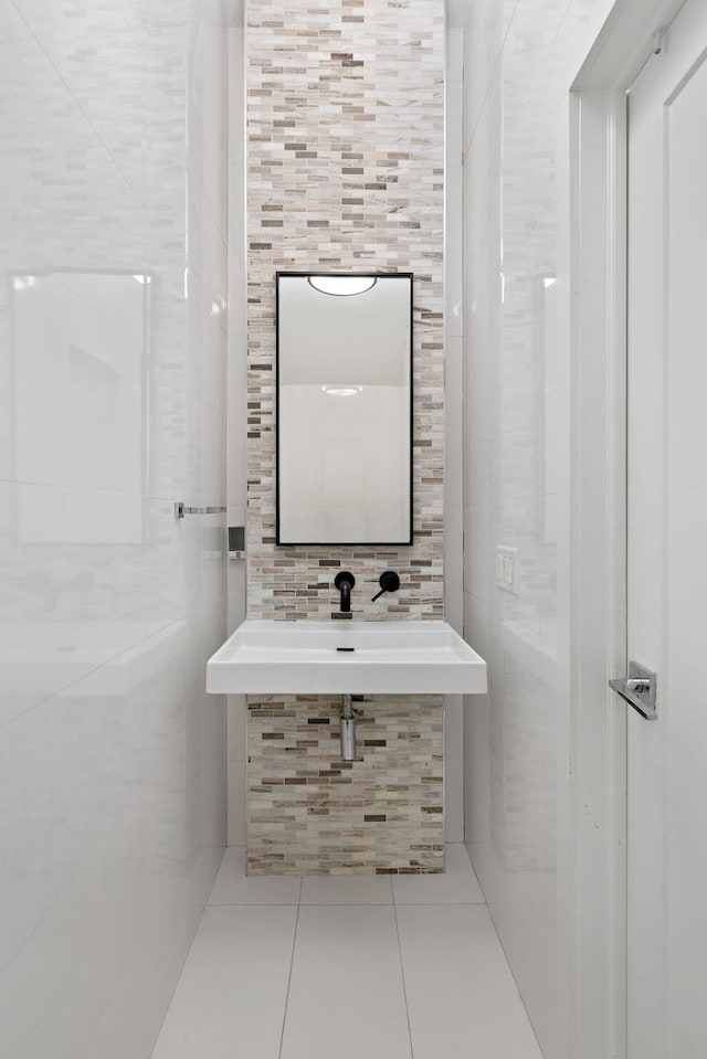 bathroom featuring tile walls, a sink, and tile patterned flooring