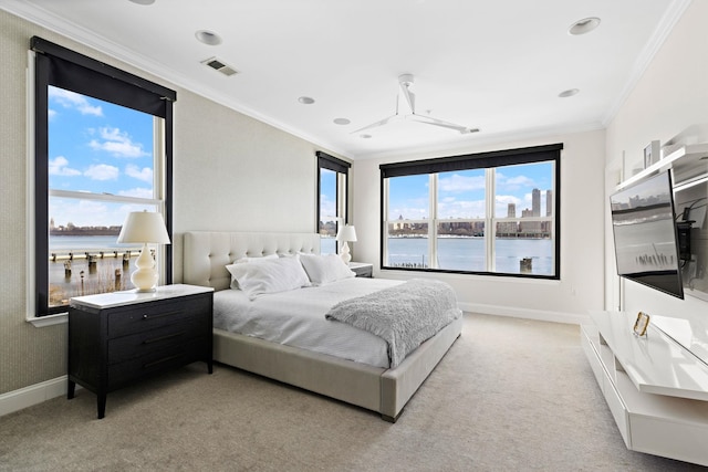 bedroom with light carpet, baseboards, a water view, visible vents, and ornamental molding