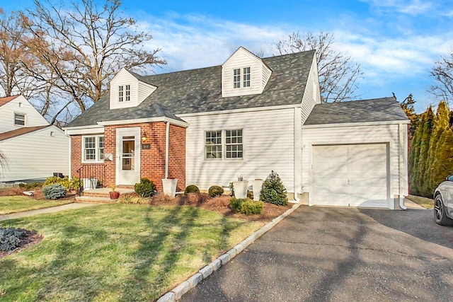 cape cod home featuring a front yard and a garage