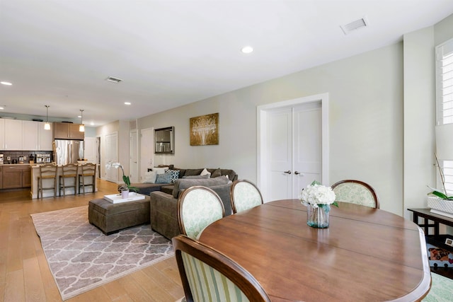 dining space with recessed lighting, light wood finished floors, and visible vents