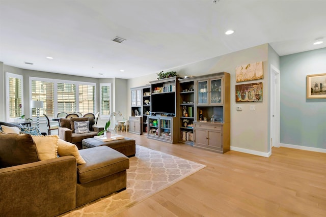 living area with recessed lighting, baseboards, and light wood finished floors