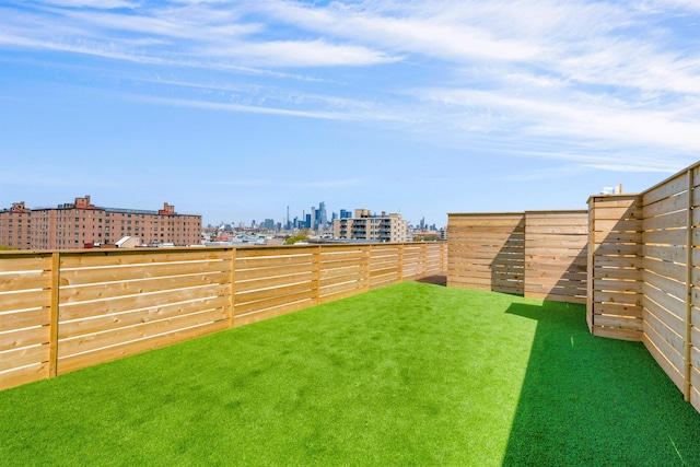 view of yard with a view of city and a fenced backyard