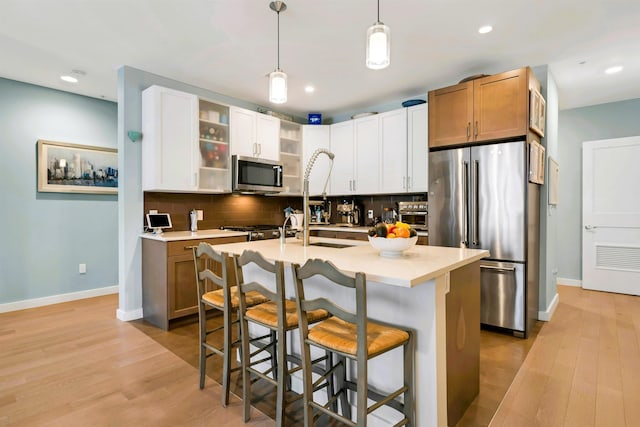 kitchen with baseboards, appliances with stainless steel finishes, a breakfast bar area, and tasteful backsplash