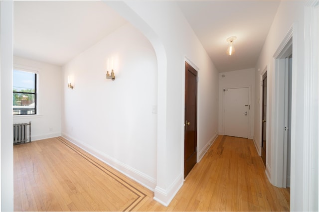 1100 83rd St Unit C1, North Bergen, NJ 07047 - corridor featuring radiator, arched walkways, and light wood-type flooring