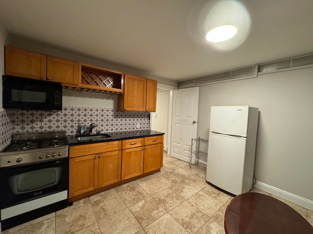 kitchen featuring tasteful backsplash, sink, white refrigerator, and gas stove