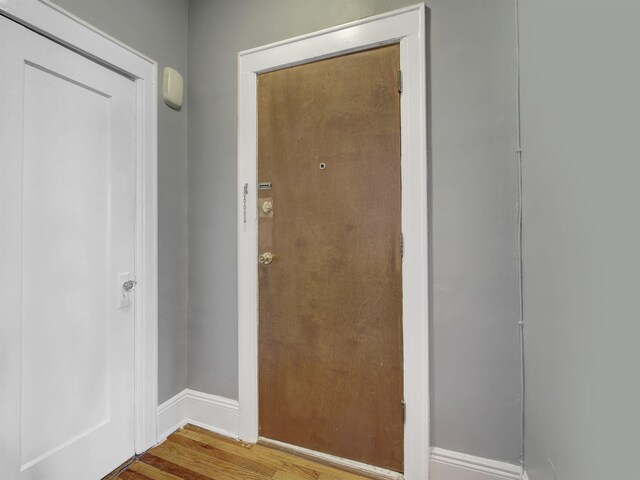 doorway to outside with baseboards and wood finished floors
