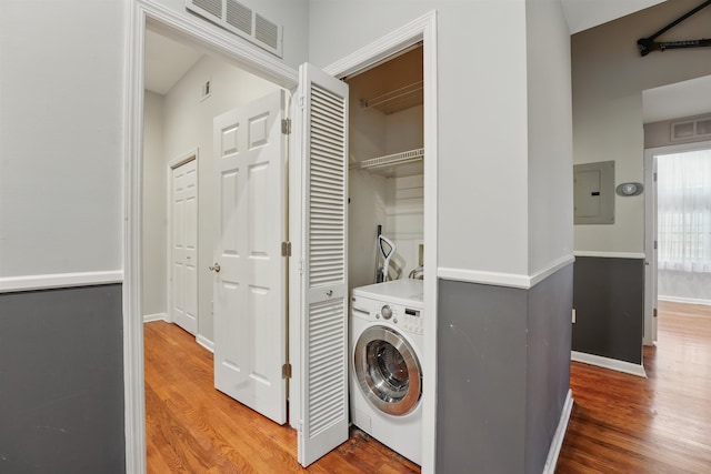 laundry room with laundry area, washer / dryer, wood finished floors, visible vents, and electric panel