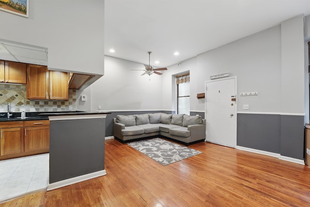living room with recessed lighting, a ceiling fan, baseboards, and light wood-type flooring