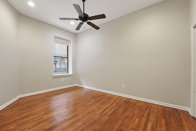 empty room with baseboards, recessed lighting, and wood finished floors