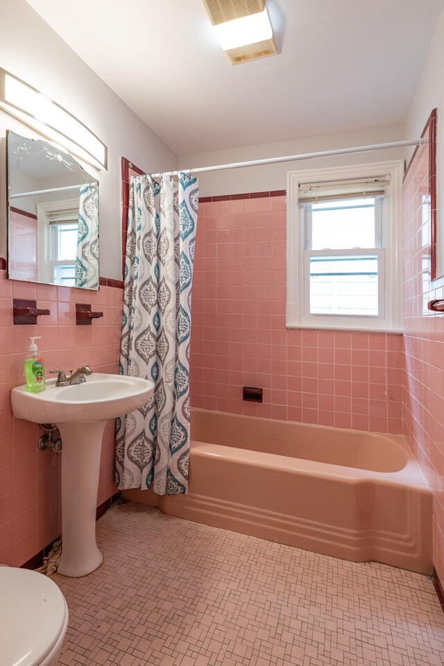 64 W 57th St, Bayonne, NJ 07002 - bathroom with tile walls, shower / bathtub combination with curtain, tile patterned floors, toilet, and wainscoting
