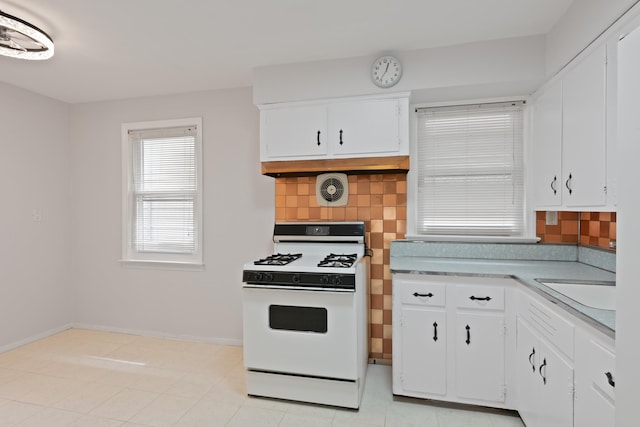64 W 57th St, Bayonne, NJ 07002 - kitchen with white range with gas cooktop, tasteful backsplash, and white cabinetry