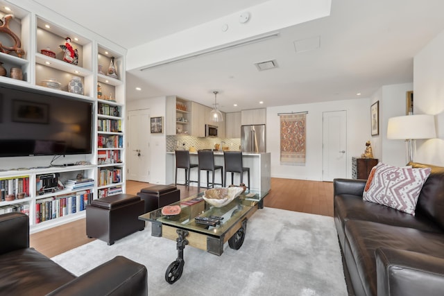 living room featuring recessed lighting, visible vents, and light wood finished floors