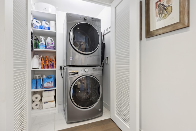 clothes washing area featuring laundry area and stacked washing maching and dryer