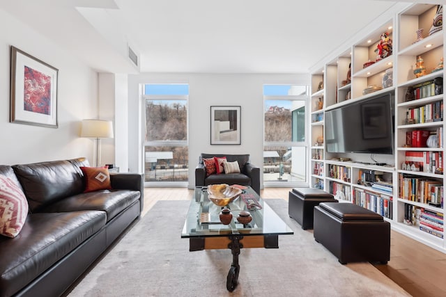 living area featuring wood finished floors, visible vents, and a wealth of natural light