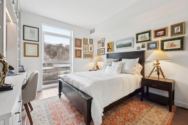 bedroom with light wood-style floors and visible vents