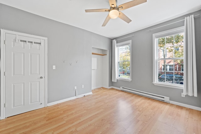 unfurnished bedroom with ceiling fan, baseboard heating, and light hardwood / wood-style flooring