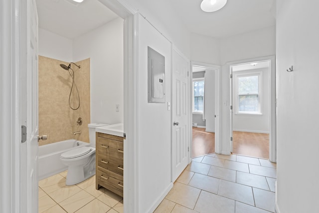 full bathroom with toilet, tiled shower / bath, tile patterned flooring, electric panel, and vanity