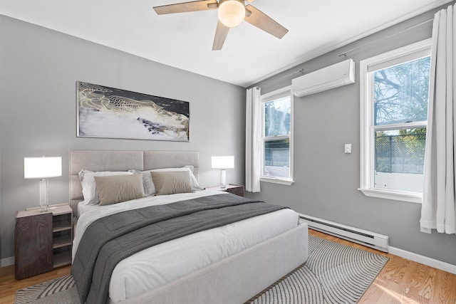 bedroom featuring ceiling fan, a wall unit AC, multiple windows, light wood-type flooring, and a baseboard radiator