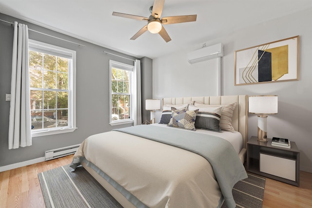 bedroom with ceiling fan, light hardwood / wood-style flooring, an AC wall unit, and a baseboard radiator