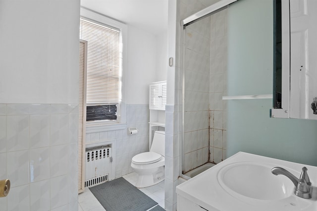 bathroom featuring tile patterned floors, radiator, a wealth of natural light, and tile walls