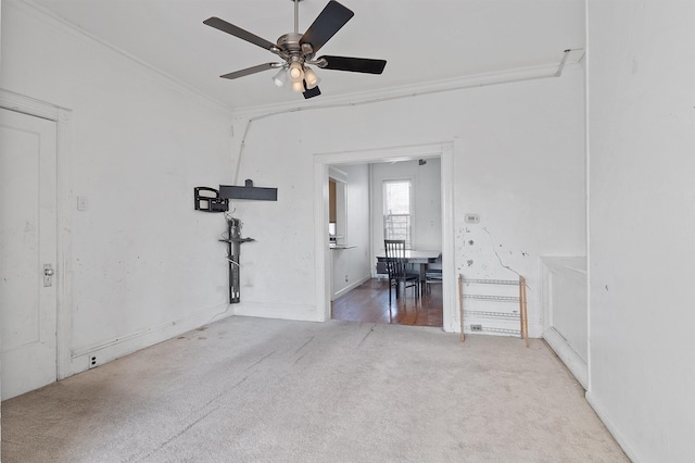 carpeted spare room with ceiling fan and crown molding