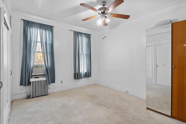 carpeted spare room featuring radiator, crown molding, and ceiling fan