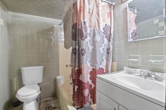 full bathroom featuring vanity, shower / bathtub combination with curtain, toilet, and tile walls