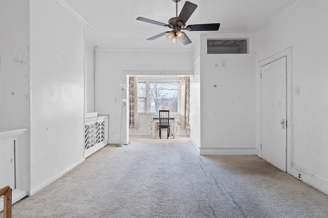 interior space with light colored carpet, ceiling fan, and ornamental molding