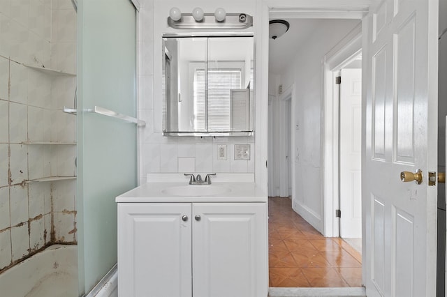 bathroom featuring combined bath / shower with glass door and vanity