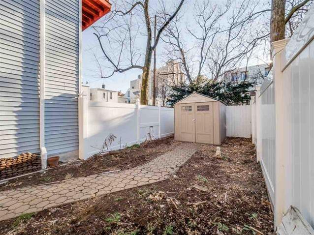 view of yard featuring a storage unit, an outbuilding, and a fenced backyard