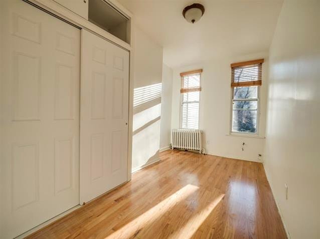 interior space with light wood-style flooring and radiator heating unit