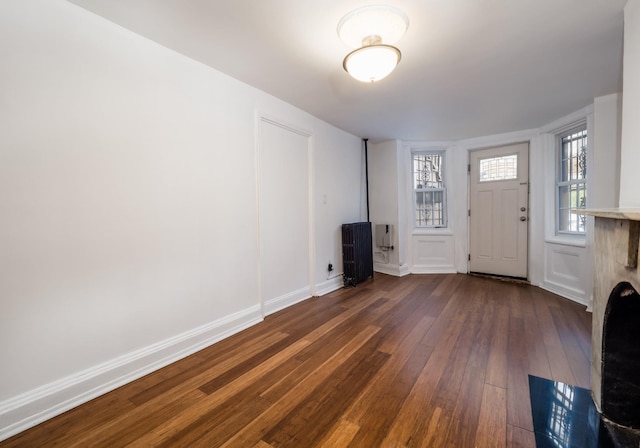 foyer with baseboards and dark wood-type flooring