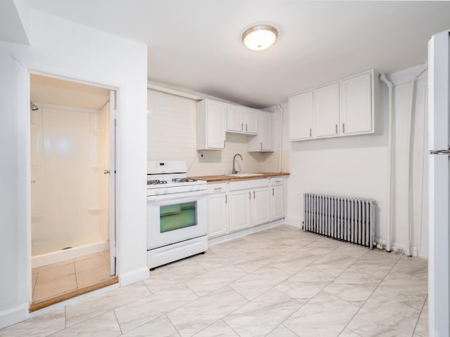 kitchen with white cabinetry, white appliances, radiator, and a sink