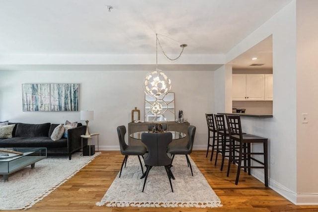dining room with recessed lighting, baseboards, a chandelier, and light wood-type flooring