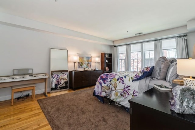 bedroom with visible vents, baseboards, and light wood-type flooring