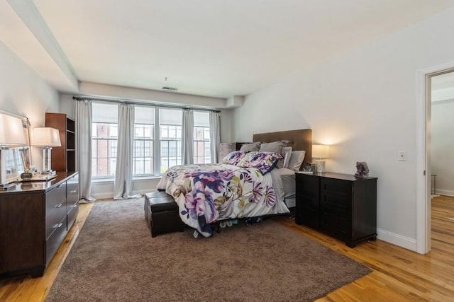 bedroom with visible vents, light wood-style flooring, and baseboards