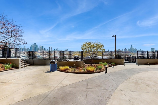 view of property's community with fence and a city view