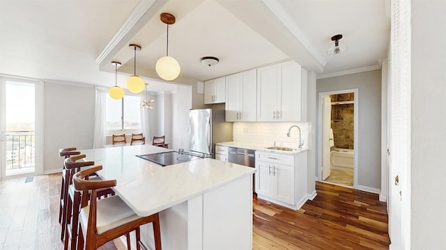 kitchen featuring freestanding refrigerator, a sink, stovetop, and wood finished floors